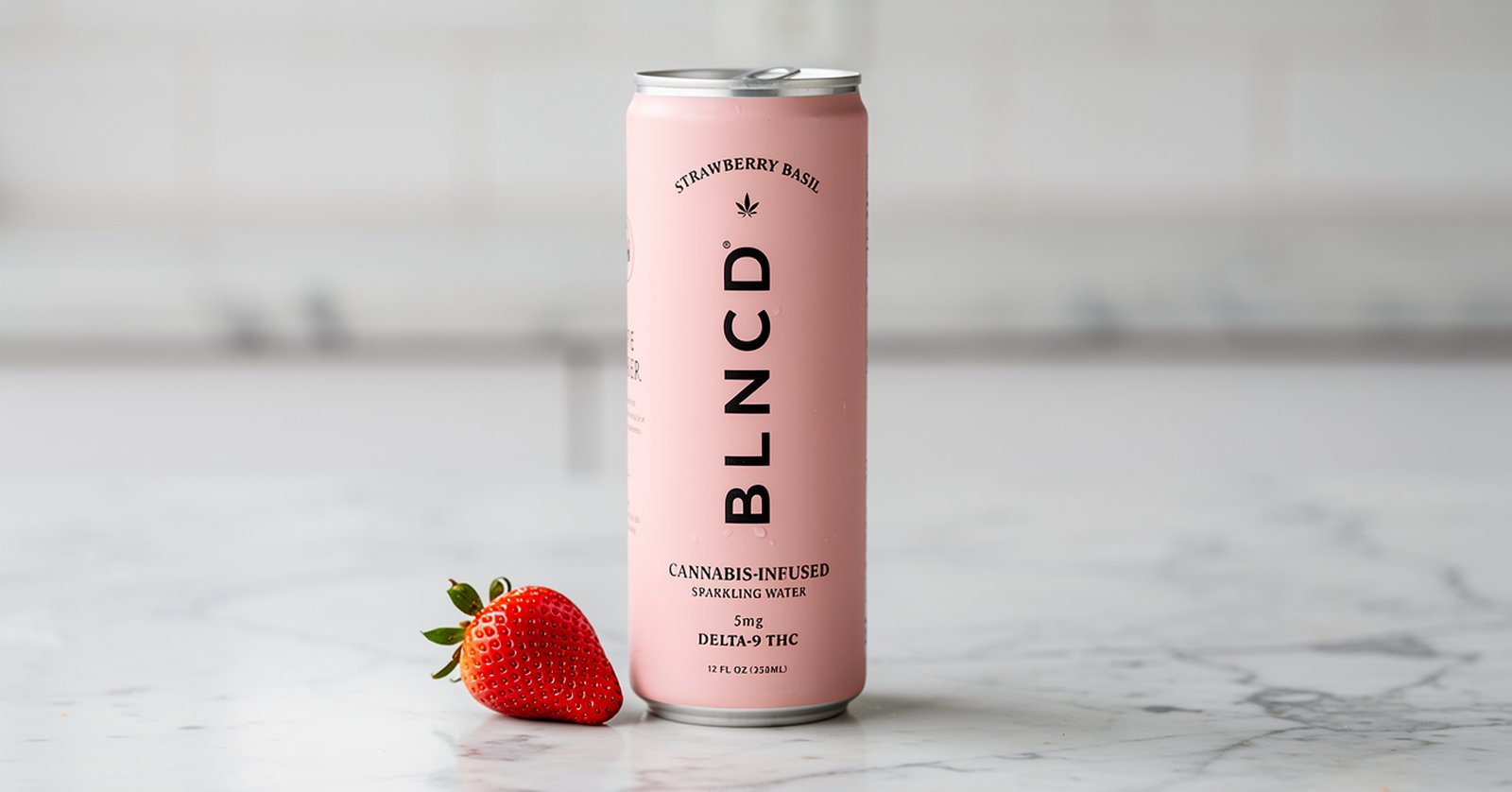 BLNCD Cranberry Basil can on a marble surface with a strawberry