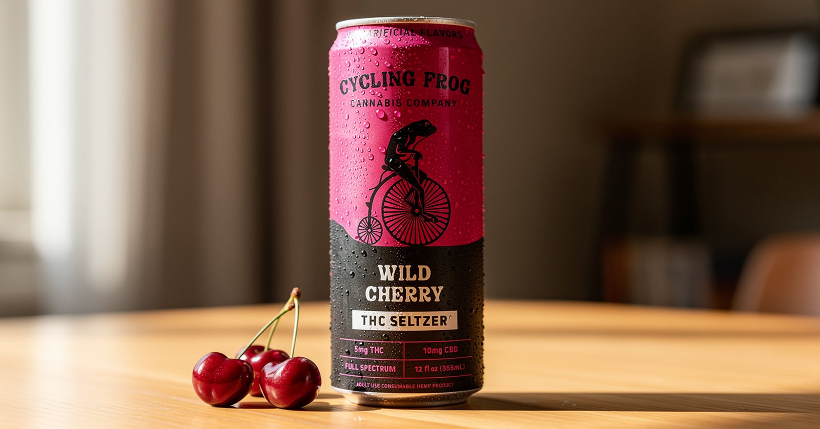 Cycling Frog Wild Cherry lifestyle THC CBD seltzer can with cherries on a wooden table