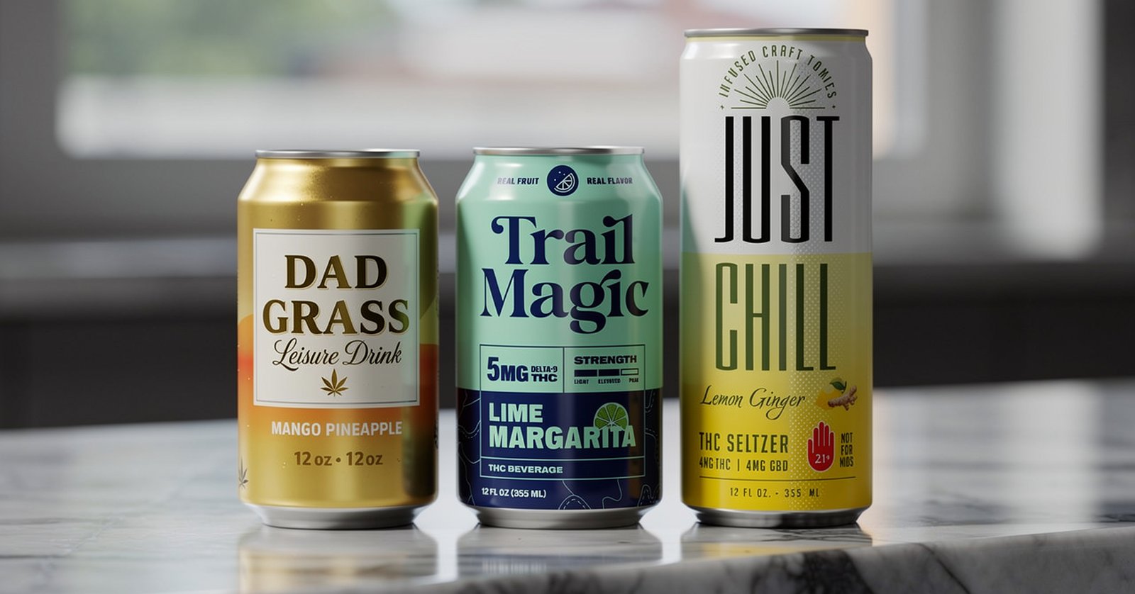 Dad Grass, Trail Magic, and Just Chill cans on a dark countertop