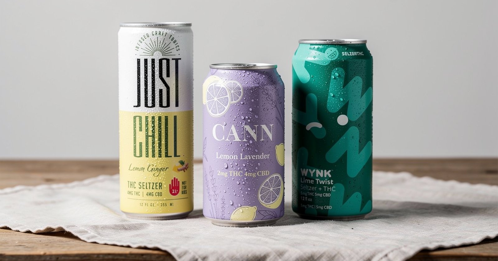 Just Chill Lemon Ginger, Cann Lemon Lavender, and Wynk Lime Twist cans on a linen cloth